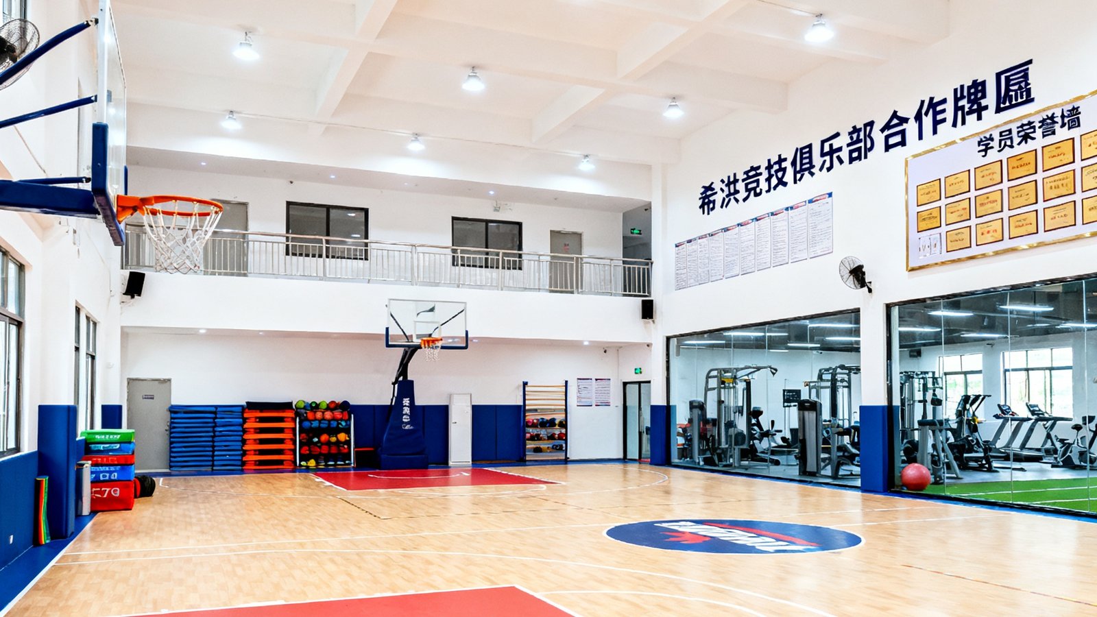 Cmp冠军体育广州天河训练中心内景全景图，明亮的场馆内设有标准篮球场和体适能训练区，墙上悬挂着希洪竞技俱乐部合作牌匾和学员荣誉墙